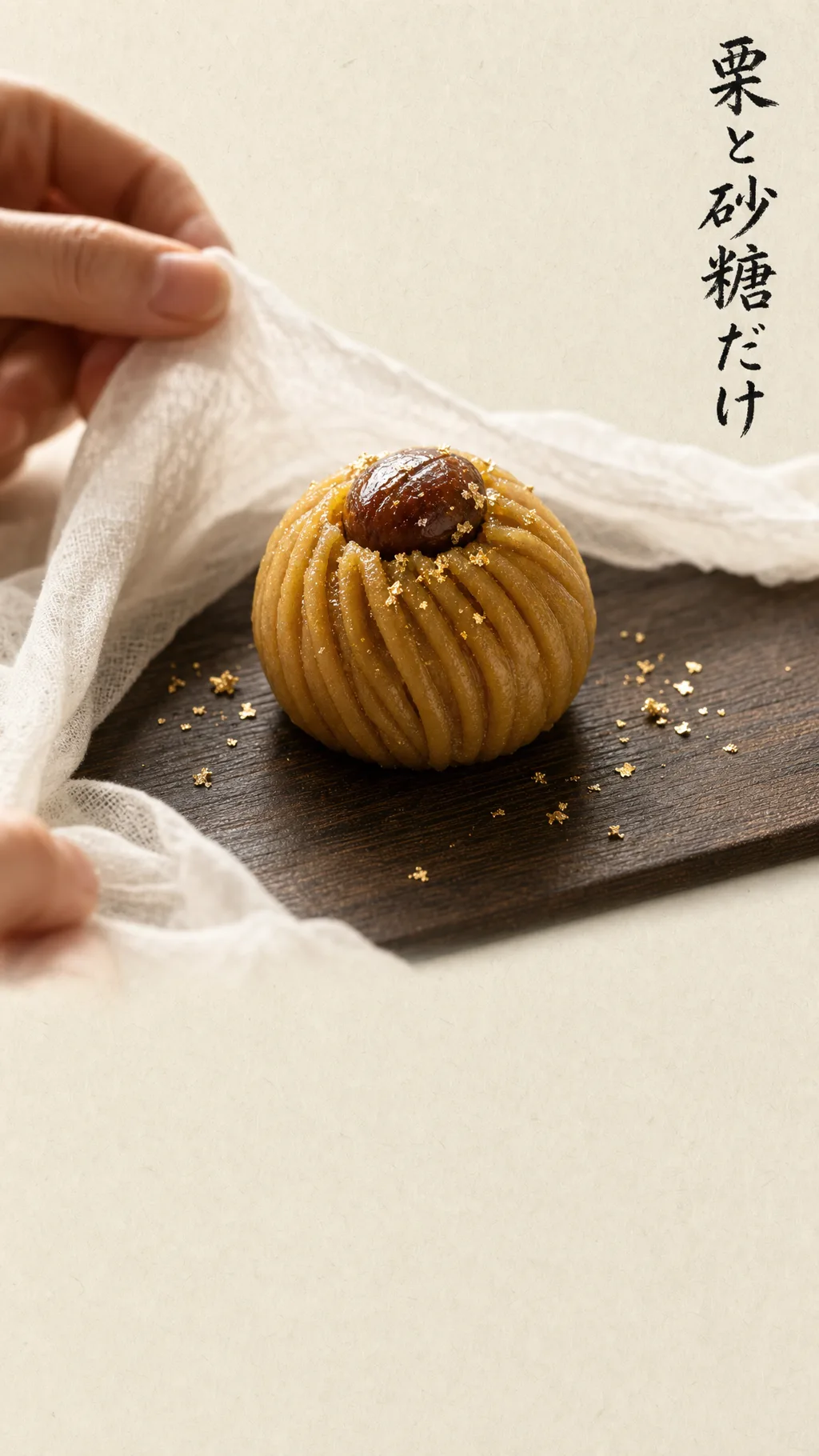 栗と砂糖だけ。職人がさらしを開き、茶巾絞りの筋がくっきりと出た栗きんとんが一つ、黒い木のまな板の上に現れる。金箔がわずかに散っている。